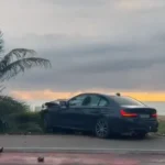 BMW desvia de motociclista, invade calçada e derruba coqueiro na orla de Maceió