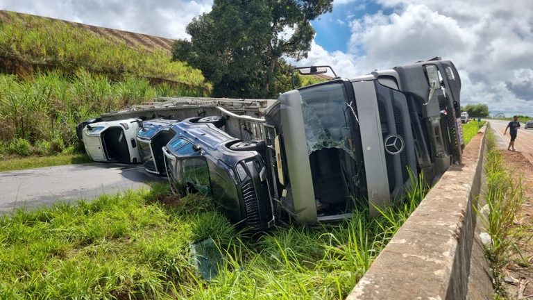 Caminhão carregado com veículos tomba e interdita a BR-101